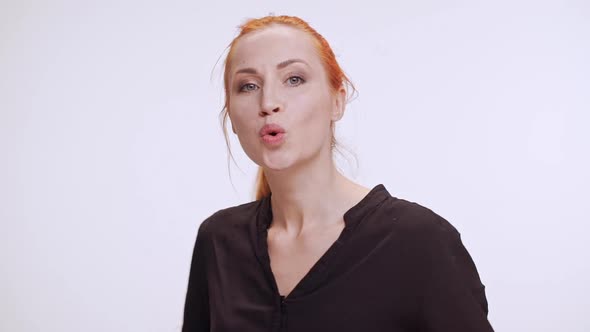 Beautiful Caucasian Female with Colored Orange Hair Whistling and Waiting on White Background