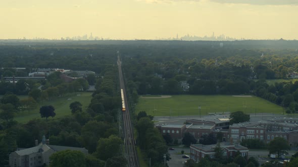 Garden City Aerial of Train Passing and New York City Skyline Seen from Afar