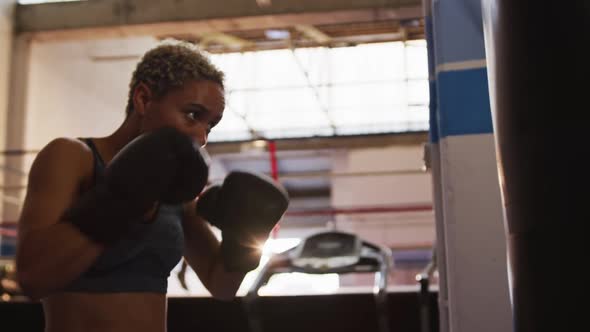 Mixed race woman boxing in punchbag