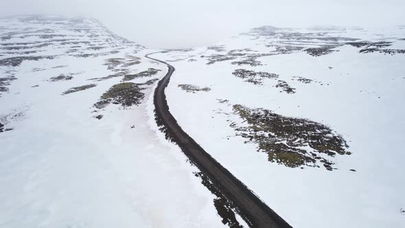 Reversing above a road to reveal more of the the fog covered frozen landscape