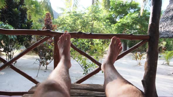 POV of Man Legs on the Tropical Hotel Veranda Summer Vacation Zanzibar Africa