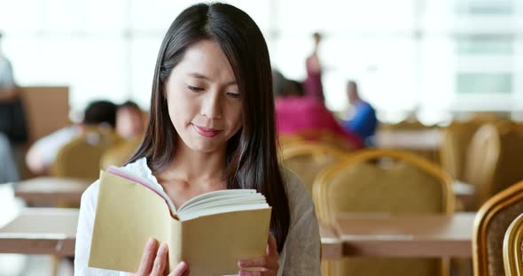 Woman reading book inside coffee shop