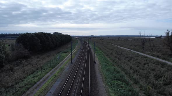 Dutch train driving over a railway track in the netherlands. Steady drone shot