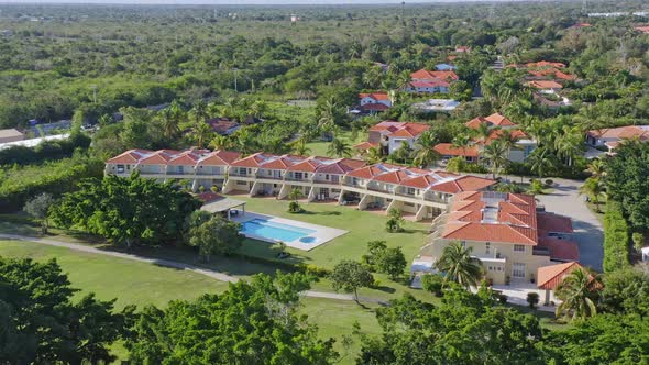 Aerial view showing luxury Metro Country Club Resort with pool and garden area during summer day - J