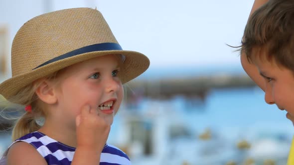 Boy and Girl Change Their Hats and Laugh