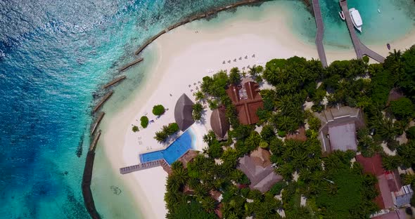 Natural fly over clean view of a white sand paradise beach and aqua blue ocean background in vibrant