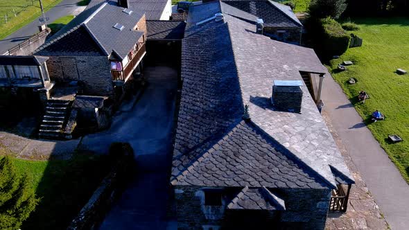 Aerial drone backward moving shot over an old house made of stone walls been converted into rural to