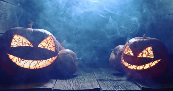 Orange and illuminated Halloween pumpkin with smoke and light.