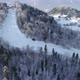 Aerial view of ski slope and skiers skiing down the slope. Winter scenery, trees covered with snow - VideoHive Item for Sale