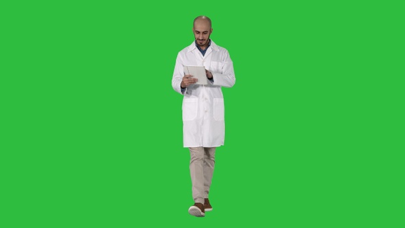 Mature Male Doctor Holding Digital Tablet Using It