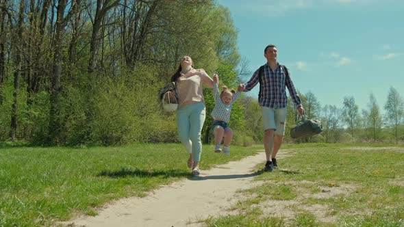 Happy Family Resting in Nature Near the Forest