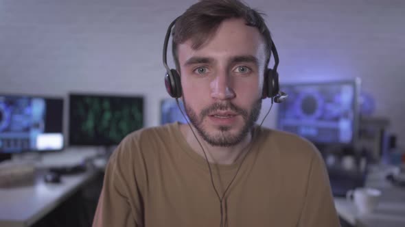 Computer POV of Absorbed Gamer Playing Video Games. Portrait of Young Caucasian Man in Headphones