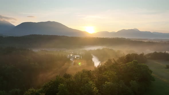 Flying over a river in mist on a beautiful sunrise