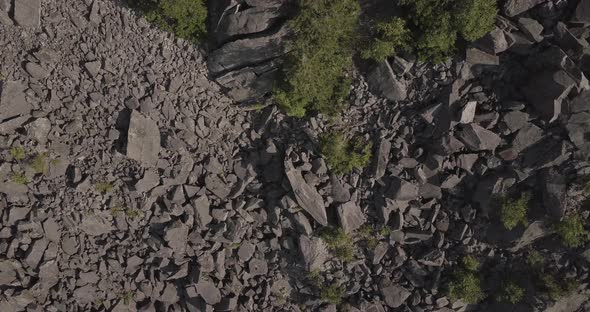 Aerial Drone Shot Flying Down Over Pile Of Rocks By Mountain