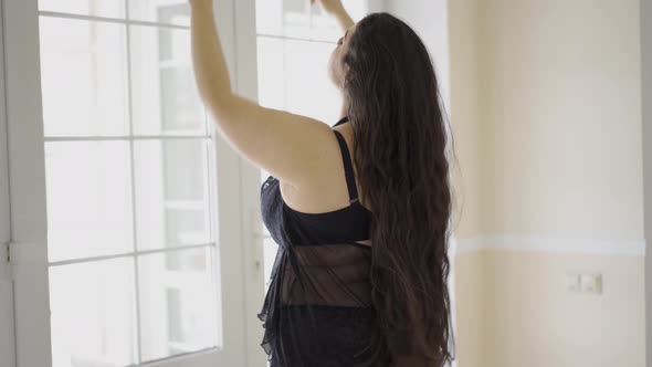 Bohemian Plump Woman with Appetizing Shapes Standing Near Window in Beautiful Underwear and Saucy