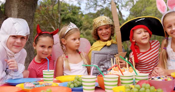 Group of kids in various costumes having breakfast