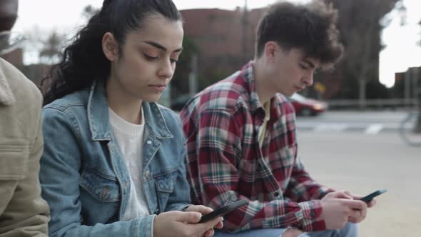 Group of Multiracial Teenage Student Friends Using Mobile Phone Together