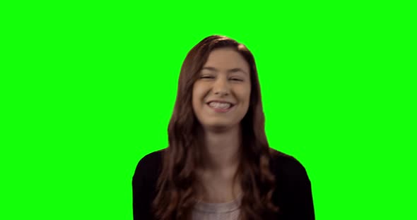 Smiling beautiful woman standing against green screen