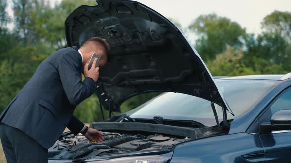 Man Looks at the Idle Car Engine