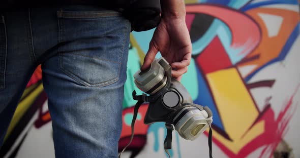 Graffiti artist holding protective mask 4k