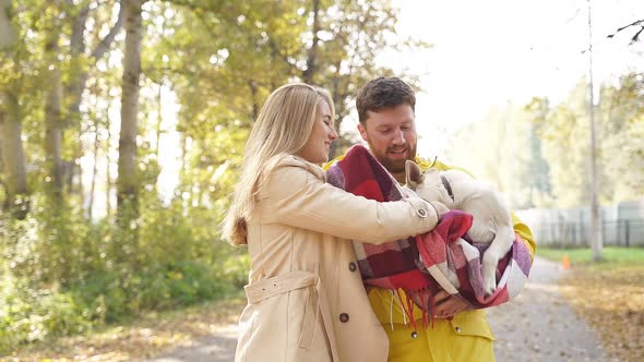 Man Woman Wrapped Their Pet Dog Checkered Blanket Outside Park They Hold Dog Their Arms