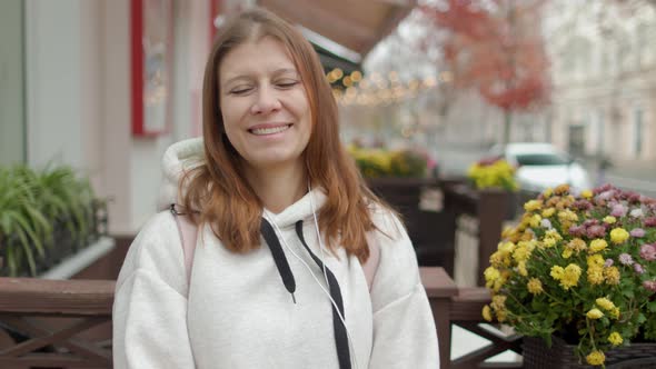 A Beautiful Woman In The City Looks Into The Camera