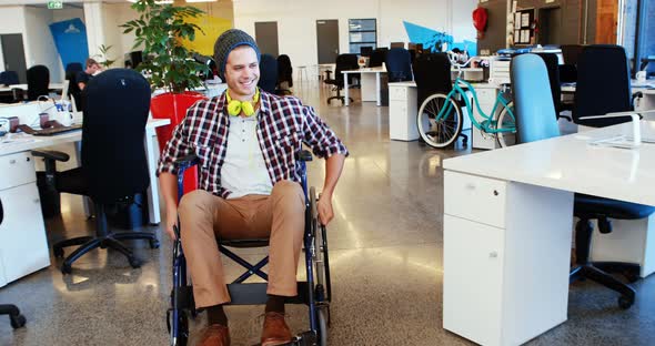 Businessman in wheelchair giving high five to coworkers