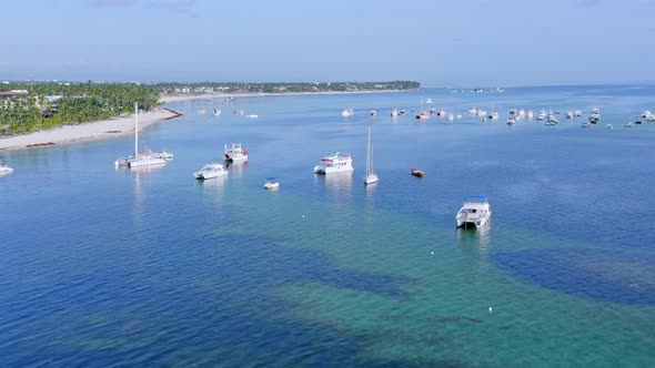 Flying Over Caribbean Sea With Boats In Bavaro, Punta Cana, Dominican Republic - aerial drone shot