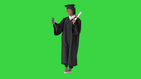 Smiling African American Female Graduate Making Selfie with Diploma on a Green Screen, Chroma Key.