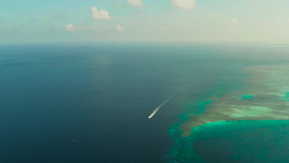 Seascape, Coral Reef and Blue Sea with Motorboat. Balabac, Palawan, Philippines