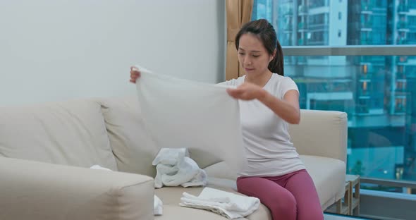 Woman fold towel at home