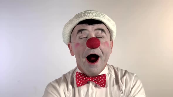 Emoji Clown - Sneezing Face. A mime clown sneezes and has a drop of mucus on his nose, then falls sl