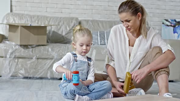 Shy Girl Playing with Toy in New Apartment alt