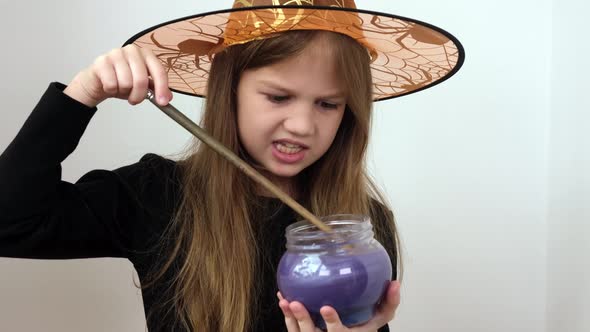 Little Girl in Orange Witch Hat is Making Magic Potion