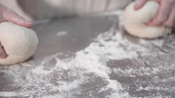 Close Up View of Bakers Hands Kneading the Dough on the Table