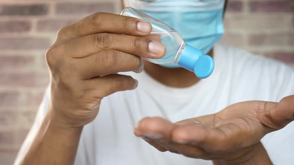 Man in Face Mask Using Sanitizer Liquid for Preventing Corona Virus