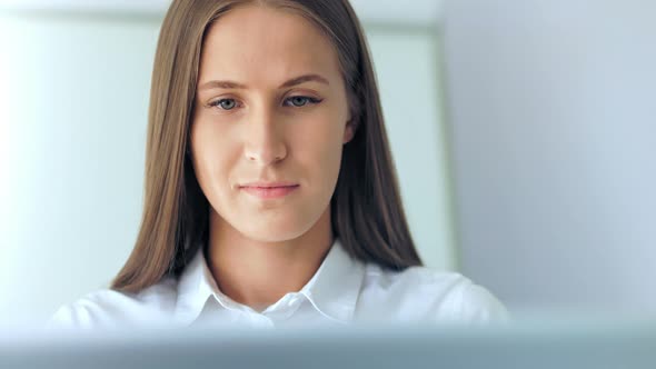 Beautiful Businesswoman Working with Laptop in White Office