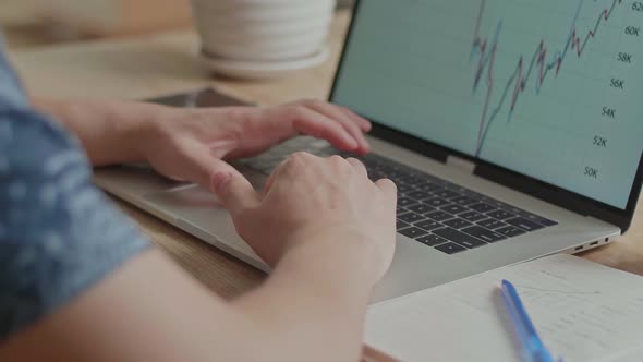 Man Looking At Financial Data With Graphics And Charts While Work On A Laptop Computer