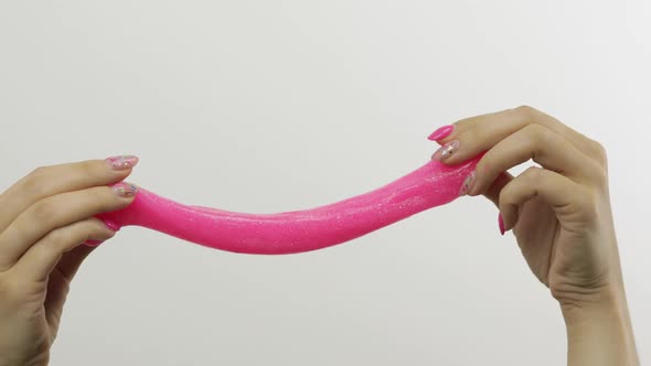 Woman Hands Playing Oddly Satisfying Pink Slime on White Background. Antistress