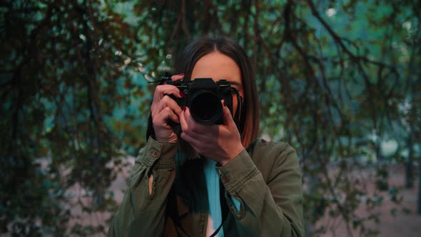 Girl in nature taking frontal photo looking at camera, Close-up portrait, handheld