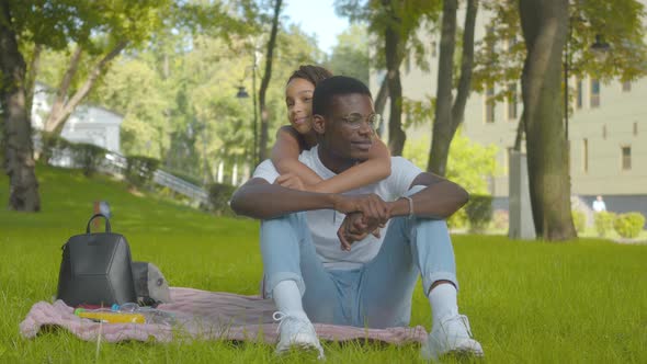 Happy African American Sister Hugging Brother in Sunny Summer Park. Portrait of Cheerful Siblings