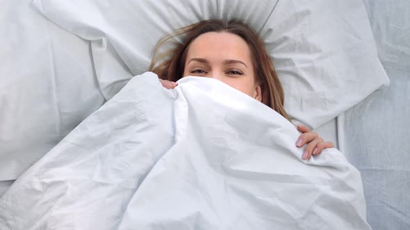 Top View Laughing Blonde Female Enjoying Playing Hide Face By Duvet