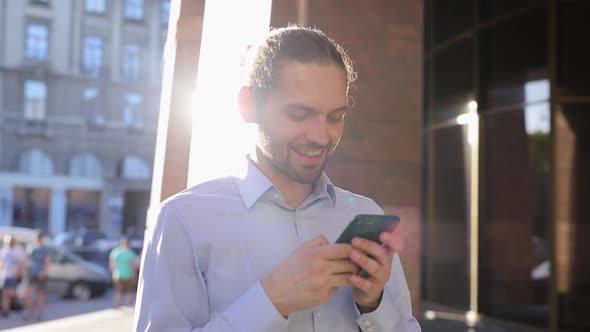 Business Man Using Mobile Phone Outdoors On Sunny Day At Street