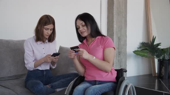 Young Caucasian Women Making Purchase Online Using Smartphone and Credit Card in Home.