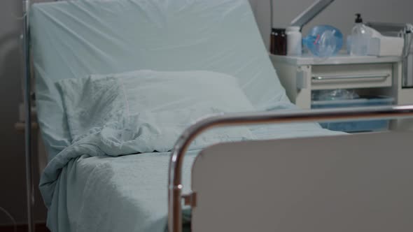 Medical Assistant Preparing Hospital Ward Bed for Patient