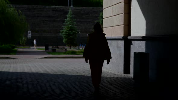 Woman is Walking in Lane of Downtown in Summer Morning Enjoying Warm Sunshine