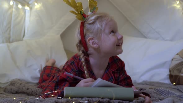 Christmas a Child Girl Writes a Letter to Santa Claus About a Gift