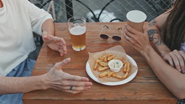 Couple of Friends Drinking Beer and Talking at Terrace