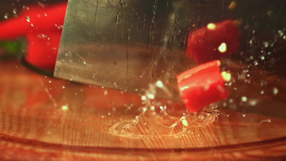 Super Slow Motion with a Large Knife Cut the Pod of Red Pepper Into Pieces