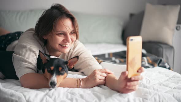 An Adult Cheerful Woman Is Taking a Videocall with Her Smartphone